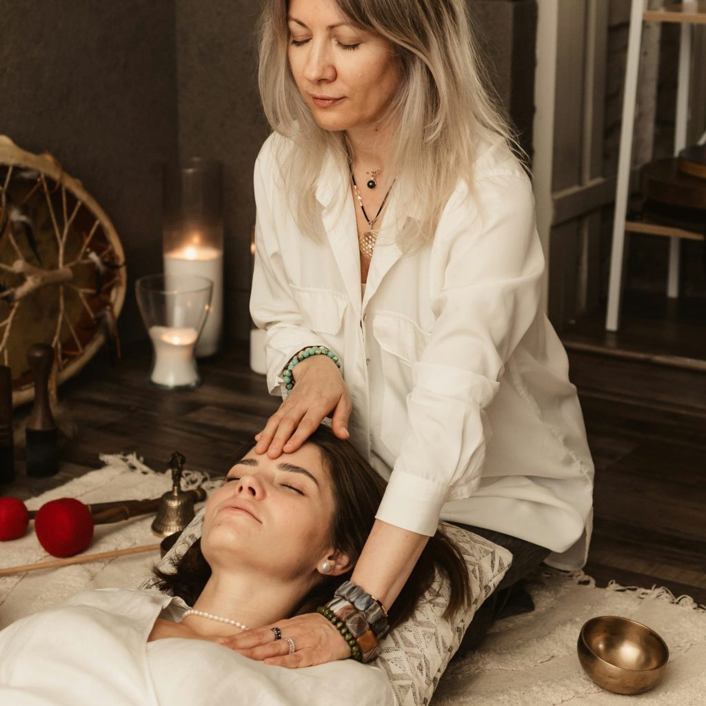 Therapist gently touching woman's forehead during session