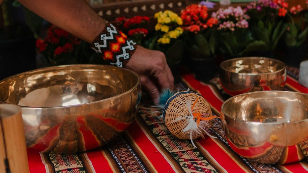 Singing bowls and ganesha statue on a colorful mat